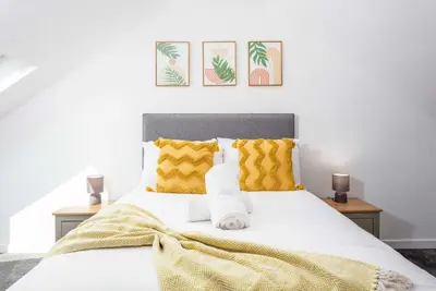 a bedroom with a white bed with yellow pillows at No20 Mansfield - Donnini Apartments in Prestwick