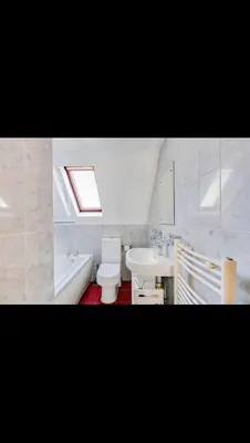 a bathroom with a sink and a toilet and a bath tub at Modern home Close to all Cardiff venues in Moffat
