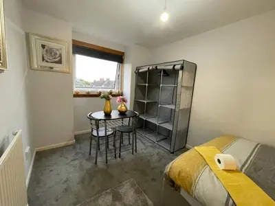 a small room with a table and a bed at Vibrant Room in Centeral Ayr in Ayr