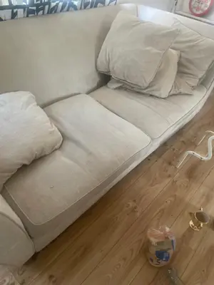 a bed with white sheets and pillows on a wooden floor at Gravesend one room apartment in Moffat