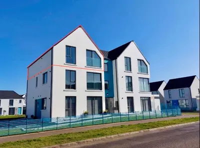 a large white house with black roof at Stylish apartment in Portstewart in Moffat