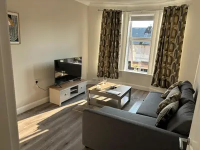 a living room with a couch and a tv at 2 bedroom first floor flat- Bonnie Stays in Troon