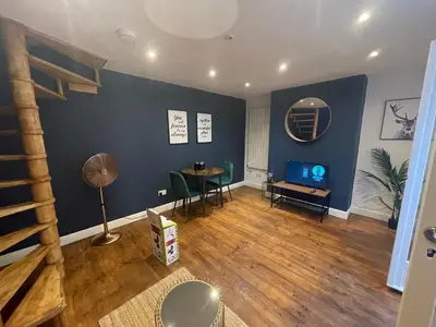 a living room with a table and a blue wall at First Avenue Apartments in Moffat