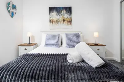 a bedroom with a large bed with two night stands at Albyn Retreat - Donnini Apartments in Prestwick