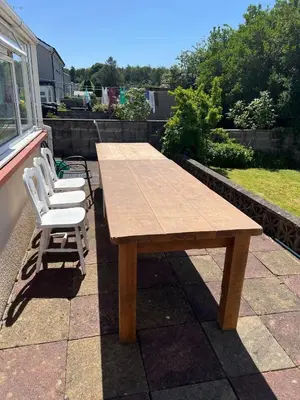 a wooden table and chairs on a patio at 2 bedroom Lake district cottage in Cockermouth