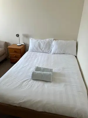 a white bed with a towel on top of it at 2 bedroom Lake district cottage in Cockermouth