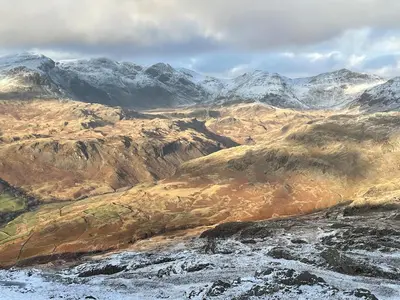 a snowy mountain range with snow covered mountains at The Old School House - Eskdale in Holmrook