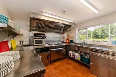 a large kitchen with stainless steel appliances and a window at The Old School House - Eskdale in Holmrook