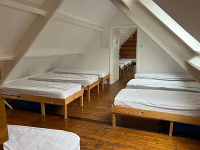 a row of beds in a room with stairs at The Old School House - Eskdale in Holmrook