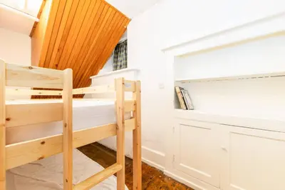 a small bedroom with a bunk bed and a closet at The Old School House - Eskdale in Holmrook
