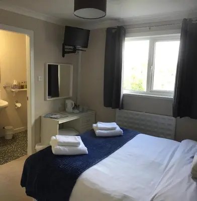 a bedroom with a bed with two towels on it at Stables Guest House in Newton Stewart