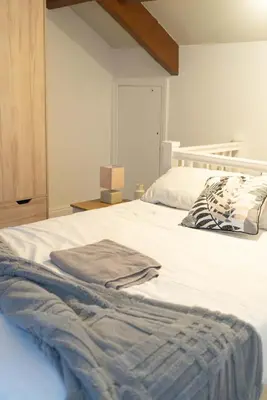 a white bed with two towels on top of it at Saint Nico in Carlisle