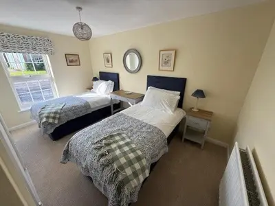 a bedroom with two beds and a window at Burn Bungalow, Longtown ideal for stop overs when travelling, 5 minutes from the M6 in Longtown