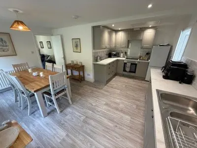 a kitchen and dining room with a table and a kitchen and a dining room at Burn Bungalow, Longtown ideal for stop overs when travelling, 5 minutes from the M6 in Longtown