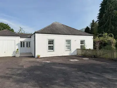 a white house with a fence and a driveway at Burn Bungalow, Longtown ideal for stop overs when travelling, 5 minutes from the M6 in Longtown