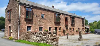 an old brick building with windows on a street at Ash Lodge at The Barn in Gosforth