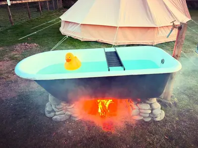 a rubber duck sitting in a bath tub next to a fire at Infinite Sky camping in Moffat