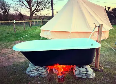 a boat sitting on top of a fire with a tent at Infinite Sky camping in Moffat