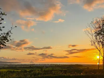 a sunset over the water with the sun in the sky at High Wardneuk - Uk47041 in Symington