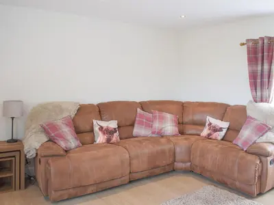 a brown leather couch with four pillows on it at High Wardneuk - Uk47041 in Symington