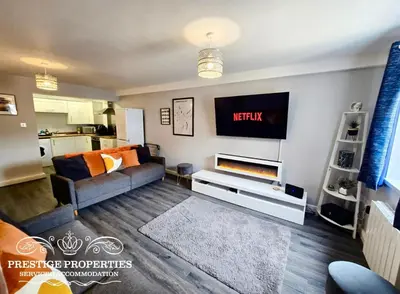 a living room with a couch and a tv at 12 Seacote Garden by Prestige Properties SA in St Bees