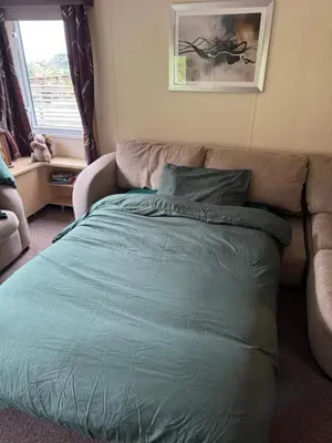 a bed in a living room with a couch at Moselle - 6 Squirrel View in Ballantrae