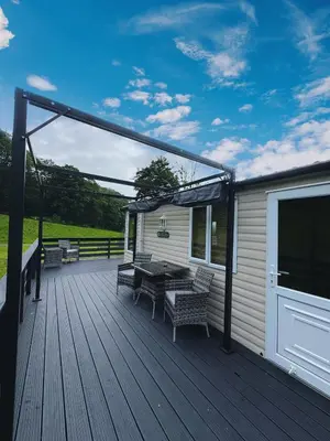 a wooden deck with a table and chairs on it at Moselle - 6 Squirrel View in Ballantrae