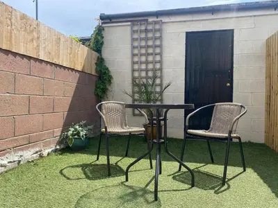 two chairs and a table in a yard at Modern 2Bed Garden Apartment in Heart of Penarth in Moffat