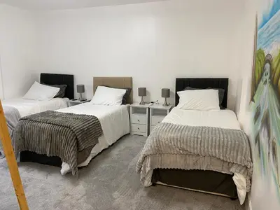 a bedroom with two beds and a desk with two lamps at Serenity Suites in Douglas