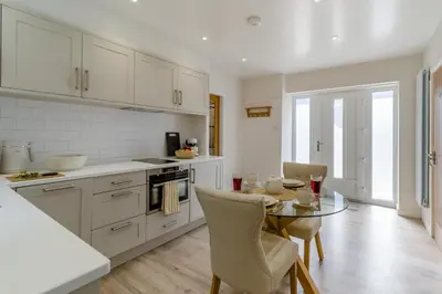 a kitchen with white cabinets and a table with chairs at 1 Bed in Dalston oc-s32206 in Dalston