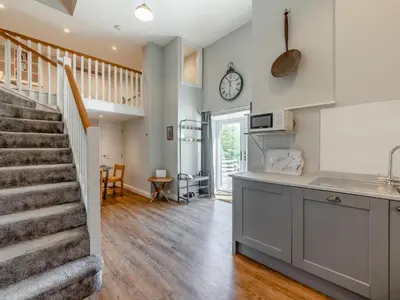 a kitchen and staircase in a home with white walls at Tower Cottage in Glenridding