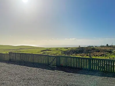 a wooden fence with the ocean in the background at Douglas - Uk49286 in Stranraer