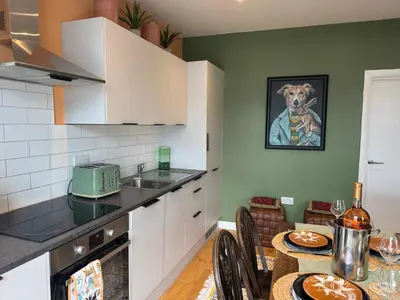 a kitchen with a table and a dog painting on the wall at Jett Joy in Moffat