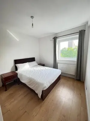 a bedroom with a large bed and a window at Flat in London Bridge in Moffat