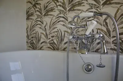 a shower in a bath tub with a shower head at Two Chimneys in Keswick