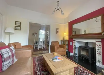 a living room with a couch and a fireplace at Two Chimneys in Keswick