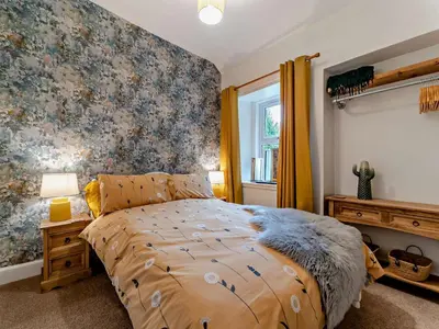 a bedroom with a bed and a floral wall at 2 Bed in Maybole 96012 in Maybole