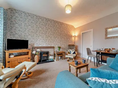 a living room with a couch and a tv at 2 Bed in Maybole 96012 in Maybole