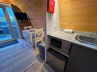 a kitchen with a sink and a table with a desk at Queensland Holiday Park - Glamping in South West Scotland in Barrhill