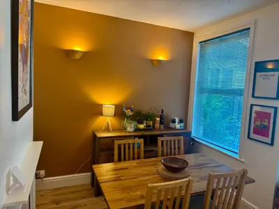 a dining room with a wooden table and a table and chairs at Southsea Home with Free Parking in Moffat
