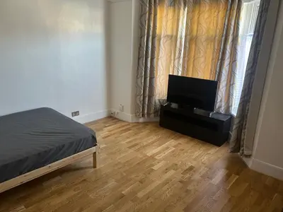 a bedroom with a bed and a flat screen tv at Flat in Moffat