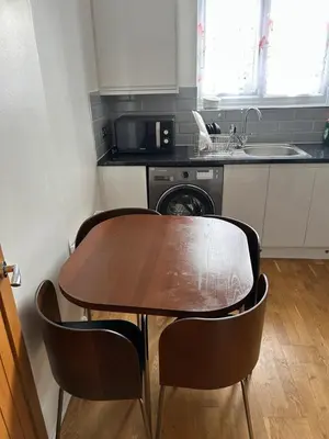 a kitchen with a table and chairs and a sink at Flat in Moffat