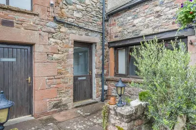 an old brick house with a door and a lamp at 2 Bed in Troutbeck oc-b32579 in Troutbeck