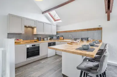 a kitchen with white cabinets and a wooden table at 2 Bed in Troutbeck oc-b32579 in Troutbeck