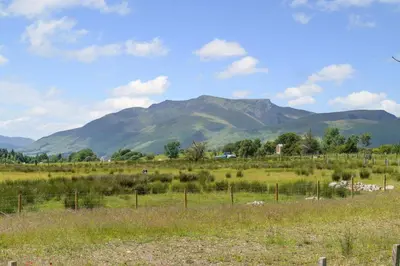 a field with a fence and mountains in the background at 2 Bed in Troutbeck oc-s32564 in Troutbeck