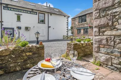 a table with wine glasses in front of a building at 1 Bed in Troutbeck oc-l32563 in Troutbeck