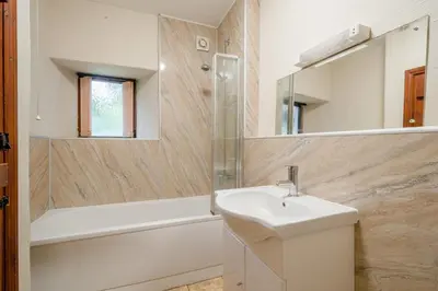 a bathroom with a sink and a mirror and a tub at 1 Bed in Troutbeck oc-l32563 in Troutbeck