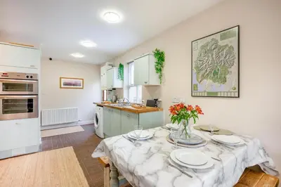a kitchen with a table with plates and flowers on it at 2 Bed in Aspatria oc-p32645 in Aspatria