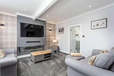 a living room with two couches and a fireplace at No15 Ellis House - Donnini Apartments in Kilmarnock