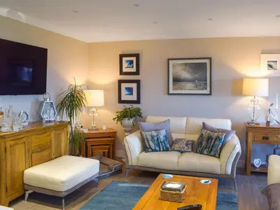a living room with a couch and a table at Bay View in Maidens